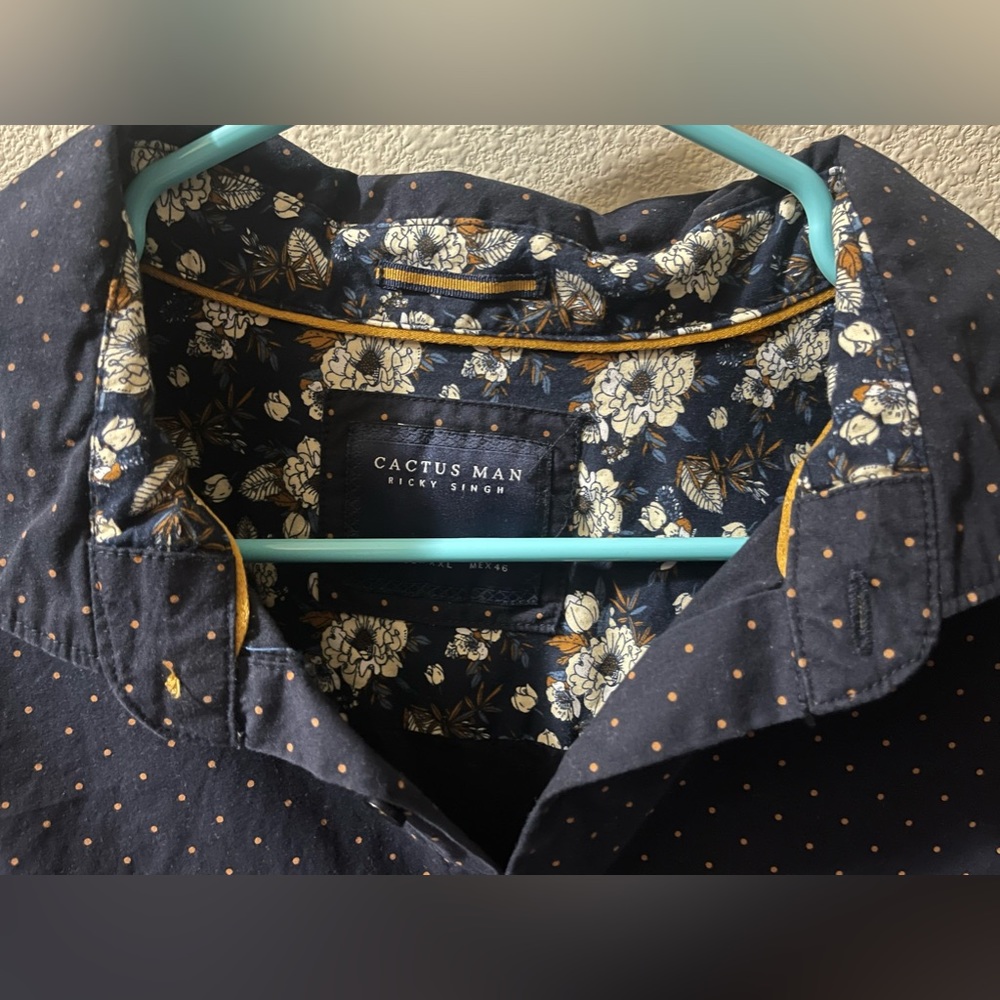 This is a blue button down shirt with gold dots around them